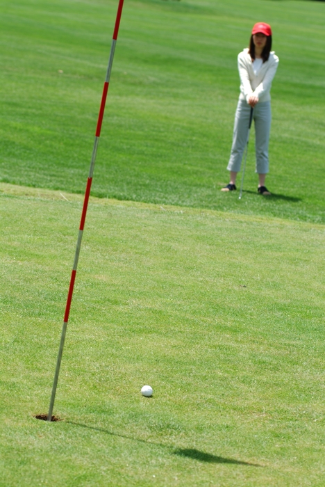 Female Golfer Watching Putt