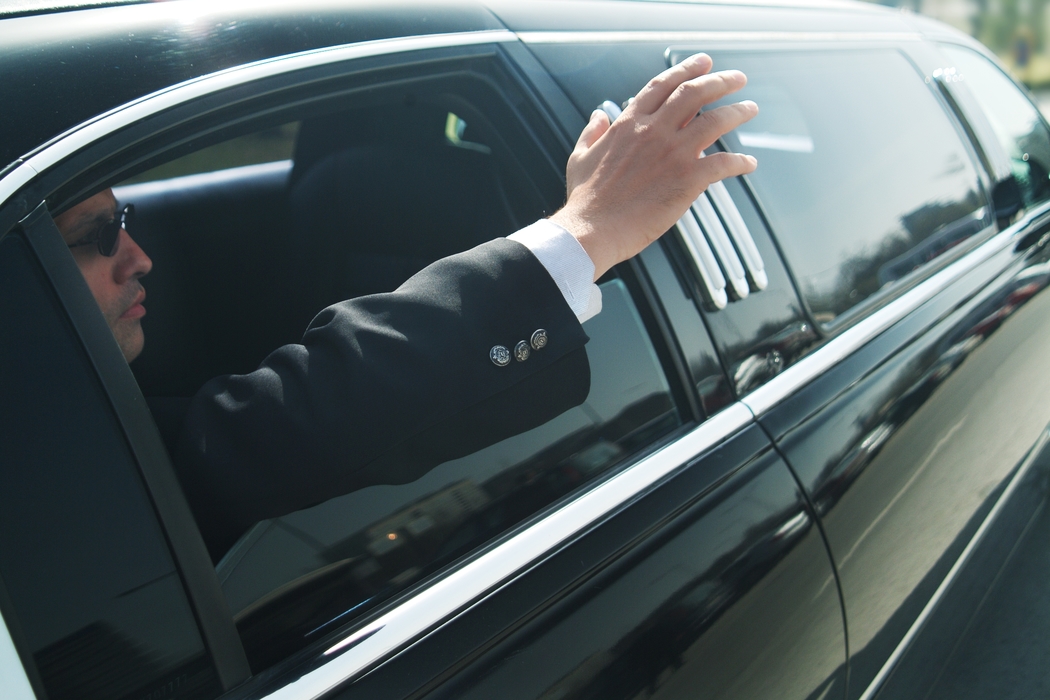 Businessman Waving From His Limousine