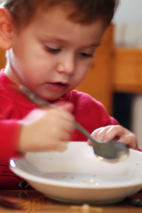 Young Boy with Breakfast Bowl and Spoon