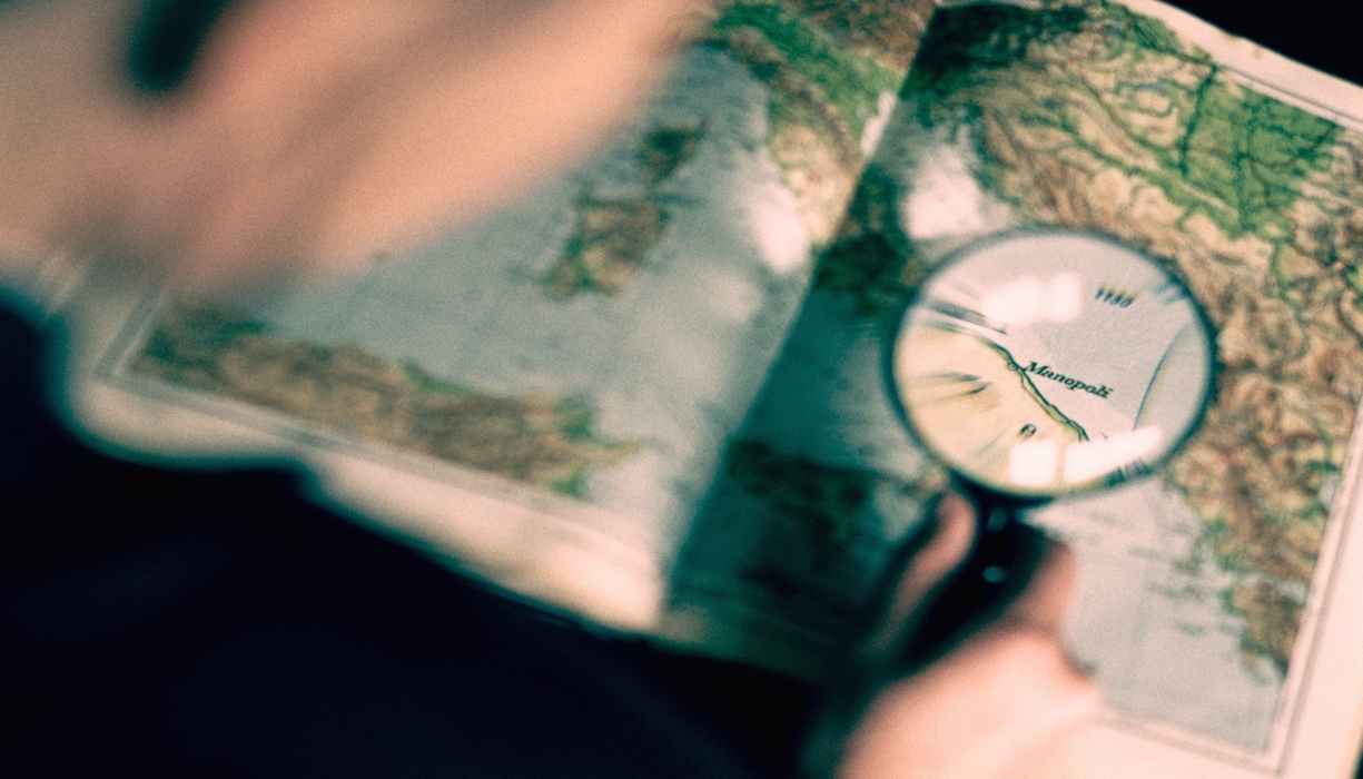 Man Looking At a Map with a Magnifying Glass