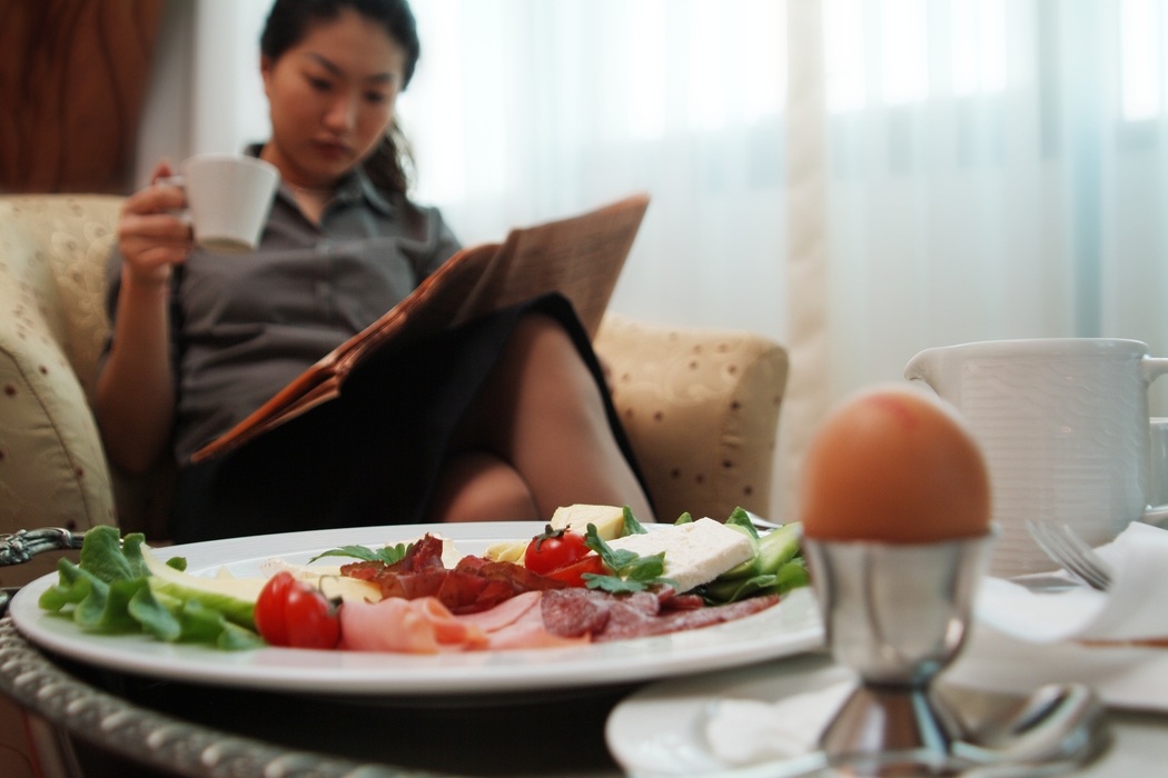 Woman Reading Newspaper After Breakfast